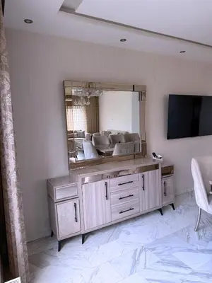 a living room with a large mirror and a television at Fully Equipped 3BR Apt in Family-Friendly Building in Amman