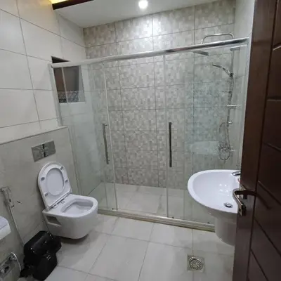 a bathroom with a shower and a toilet and a sink at Laperla luxury family apartment one in Amman