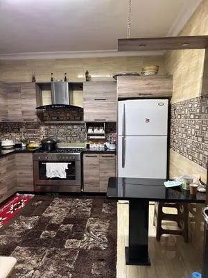 a kitchen with a refrigerator and a table in it at كريستال in Amman