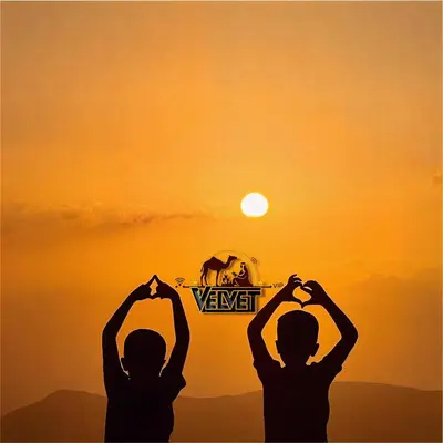 two children holding their hands up in front of the sunset at VELVET WADi RUM LUXURY in Wadi Rum