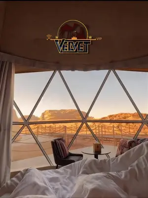 a bedroom with a bed and a view of the desert at VELVET WADi RUM LUXURY in Wadi Rum
