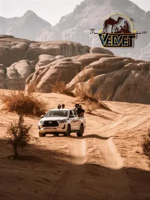 a white suv driving through the desert at VELVET WADi RUM LUXURY in Wadi Rum