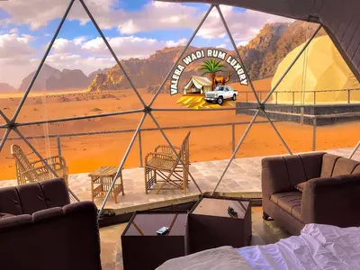 a room with a view of a desert with a car in a tent at Valera wadi rum Luxury in Wadi Rum