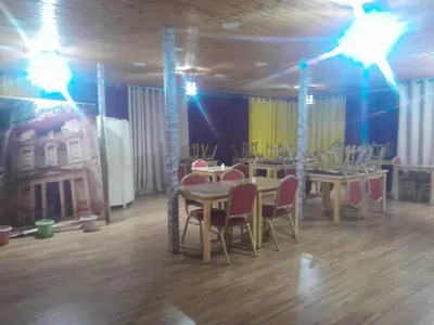 a dining room with tables and chairs and lights at bedouin hostel in Amman