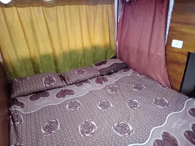 a bed in a room with pink curtains at bedouin hostel in Amman