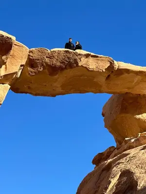 two people sitting on top of a rock formation at RUM MARS lUXURY SANDS BUBBLE CAMP in Wadi Rum
