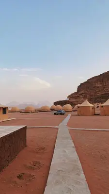 a car driving down a road in the desert at Wadi Rum Camp AW in Disah