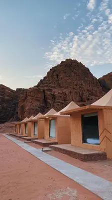 a row of buildings in the desert with a mountain at Wadi Rum Camp AW in Disah
