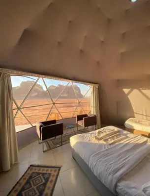 a bedroom with a bed and a large window at Welcome to Wadi Rum in Wadi Rum