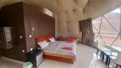 a bedroom with a bed and a large window at wadi Rum Mohammed in Wadi Rum