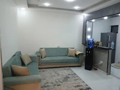 a living room with a green couch and a refrigerator at شقق السعادة 1 in Amman