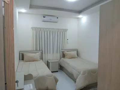 two beds in a room with white walls at شقق السعادة 1 in Amman
