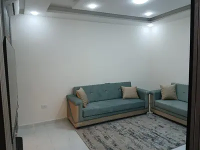 a blue couch sitting in a room with a rug at شقق السعادة 1 in Amman