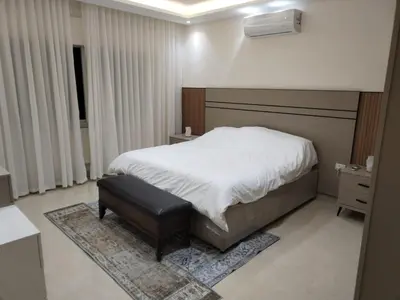 a bedroom with a bed and a stool in it at Amman Sweet-Home - 2 bedrooms Apartment in Amman