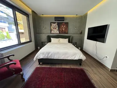 a bedroom with a bed and a flat screen tv at Bargos Cave in Amman