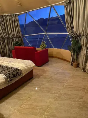 a room with a bed and a large window at Sela wadi rum in Wadi Rum