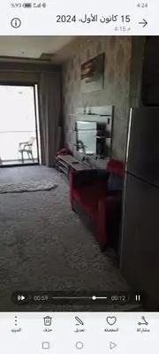 a living room with a couch and a television at برج داماك الطابق in Amman