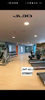 a gym with treadmills and ellipticals on a wooden floor at شقه دوبلكس داماك العبدلي in Amman
