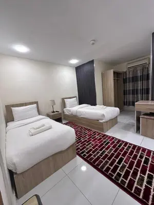 a hotel room with two beds and a rug at Uncle Ali hotel in Wadi Musa