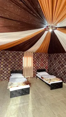 two beds in a room with a ceiling at Wadi rum camp with tour in Wadi Rum