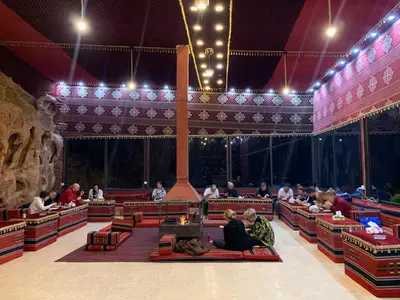 a group of people sitting on the floor of a stage at Wadi rum camp with tour in Wadi Rum