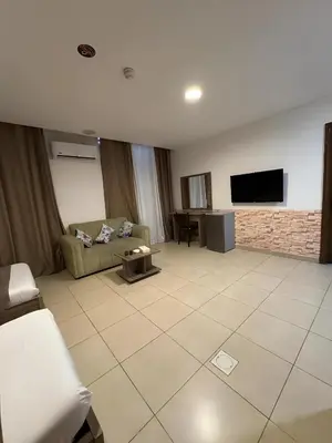 a living room with a couch and a tv at Ryan Hotel Suites in Amman