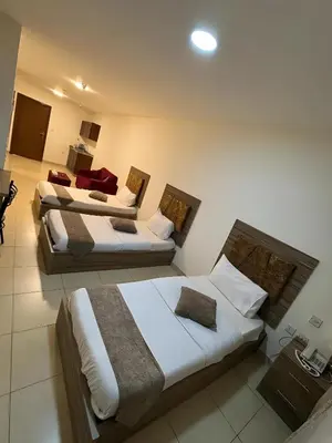 a hotel room with three beds and a tv at Ryan Hotel Suites in Amman