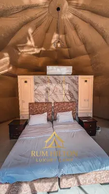 a bed in a yurt with a large comforter at RUM HiLTON lUXURY CAMP in Wadi Rum