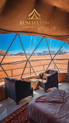 a living room with two couches and a view of the desert at RUM HiLTON lUXURY CAMP in Wadi Rum