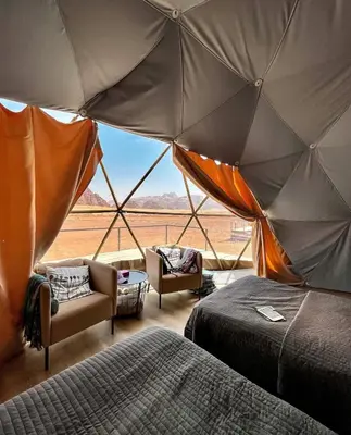a room with two beds and a view of the desert at RUM HiLTON lUXURY CAMP in Wadi Rum