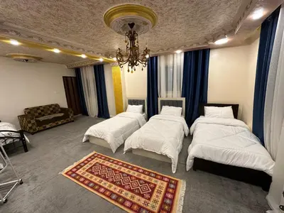 a room with three beds and a chandelier at Nora Bedouin Home in Petra
