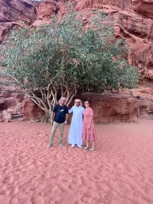 a group of three people standing in front of a tree at Nora Bedouin Home in Petra