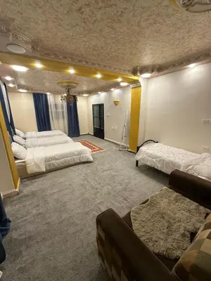a large room with two beds and a couch at Nora Bedouin Home in Petra