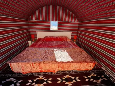 a bedroom with a bed in a striped wall at Desert Rock Wadi Rum in Wadi Rum