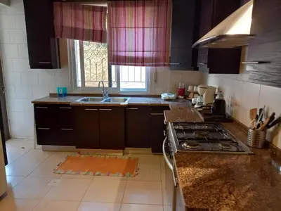 a kitchen with a sink and a stove top oven at Happy Family Home with Spacious Garden in Amman