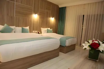 two beds in a hotel room with flowers on the floor at Turquoisejo Hotel in Aqaba