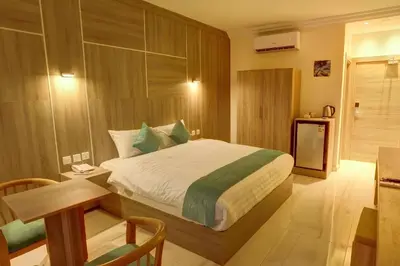 a bedroom with a bed and a table and a desk at Turquoisejo Hotel in Aqaba