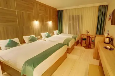 a hotel room with two beds and a table at Turquoisejo Hotel in Aqaba