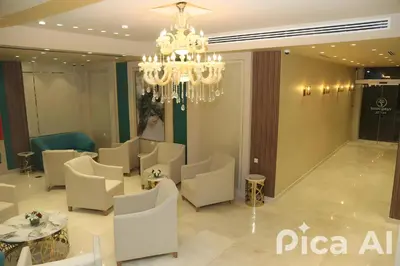 a restaurant with white chairs and a chandelier at Turquoisejo Hotel in Aqaba