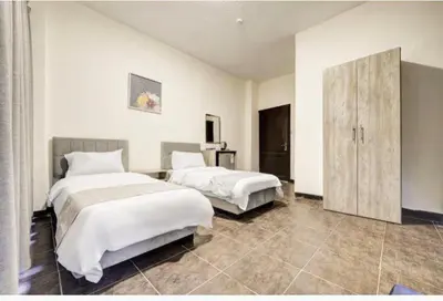 a hotel room with two beds and a cabinet at Magic Waves Hotel Aqaba in Aqaba