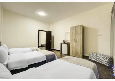 a hotel room with three beds in a room at Magic Waves Hotel Aqaba in Aqaba