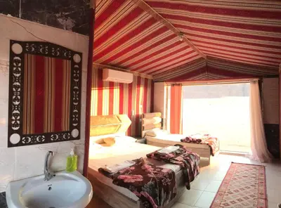 a bathroom with a sink and a bed in a room at Princess Camp in Wadi Rum