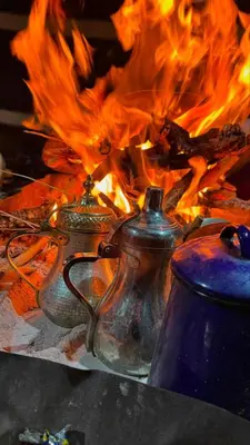 a group of tea pots in front of a fire at Princess Camp in Wadi Rum