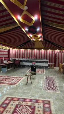 a large room with rugs and a stove in it at Princess Camp in Wadi Rum