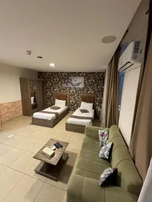 a living room with a couch and two beds at El RAYYAN HOTEL SUITES in Amman