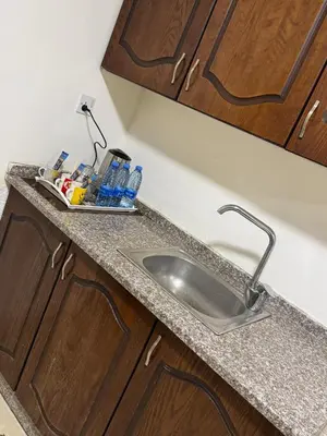 a kitchen counter with a sink in a kitchen at El RAYYAN HOTEL SUITES in Amman