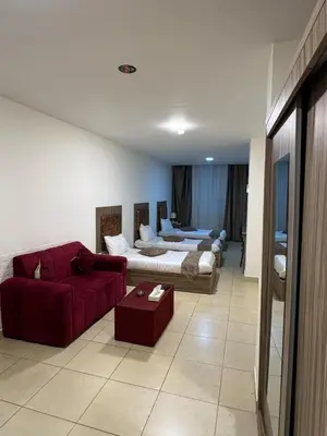 a living room with a couch and a red couch at El RAYYAN HOTEL SUITES in Amman
