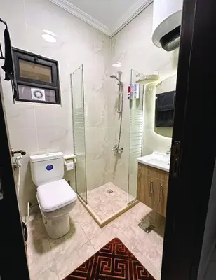 a bathroom with a toilet and a glass shower at Alsadi Housing- Jabal Amman in Amman