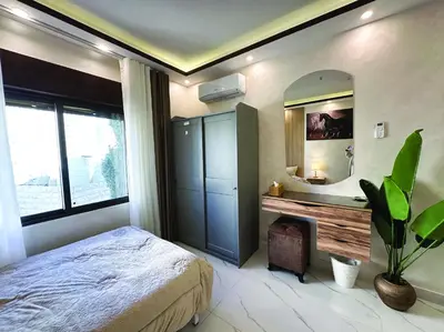 a bedroom with a large bed and a mirror at Alsadi Housing- Jabal Amman in Amman