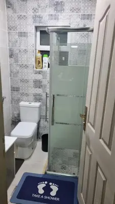 a bathroom with a toilet and a glass shower at Beit Alhana in Amman